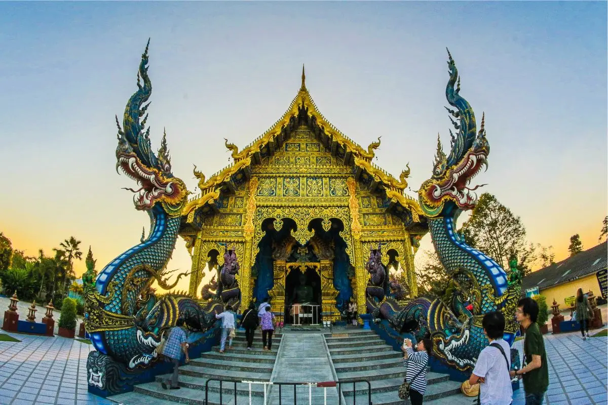 A beautiful temple in South Thailand with golden statues and peaceful surroundings.